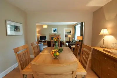 a dining room table with a vase of fruit on it at Home Farm Cottages, Glendaruel, Argyll. Scotland in Clachan of Glendaruel