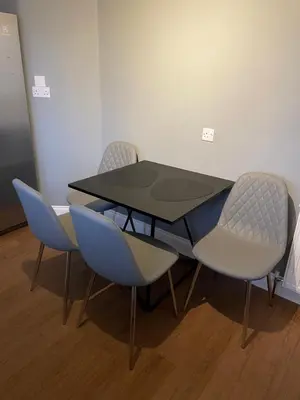 a table and four chairs in a room at Windsor House in Falkirk