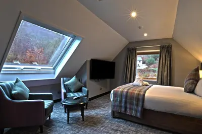 a hotel room with a bed and a window at The Beach House Loch Lomond in Luss