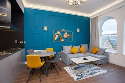 a blue living room with a couch and a table at Stunning One bed with parking in City Centre in Glasgow