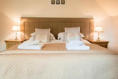 a bedroom with a large bed with two towels on it at The Granary with Hot Tub in Forgandenny