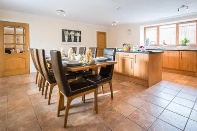 a kitchen and dining room with a table and chairs at The Granary with Hot Tub in Forgandenny