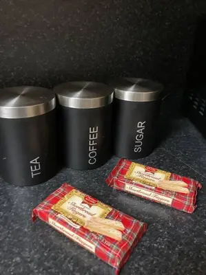 a table with two cups and two bags of hot dogs at Budget friendly apartment with stairs Near Glasgow airport and Loch Lomond in Clydebank