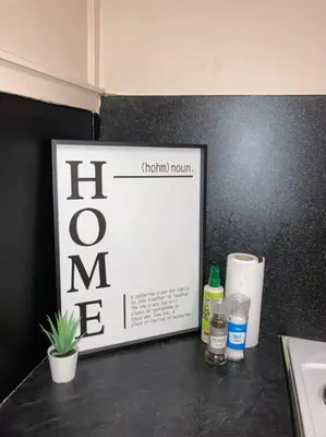 a black counter top with a sign on a wall at Budget friendly apartment with stairs Near Glasgow airport and Loch Lomond in Clydebank