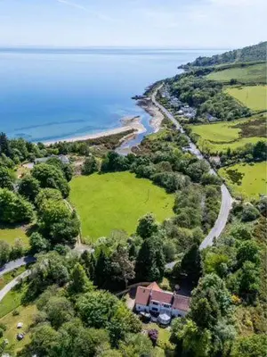 an aerial view of a house on a hill near the water at The Best Moments Start Here in Corrie