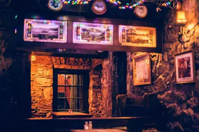 a bar with a window and pictures on the wall at The George Hotel in Inveraray