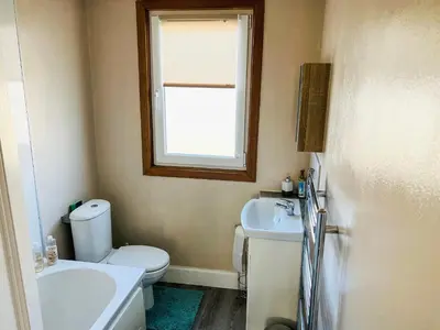 a bathroom with a toilet and a sink and a window at The Wee Pad - Uk42918 in Dunfermline