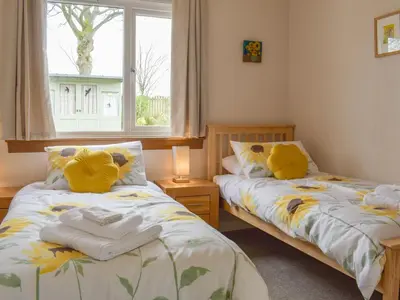 two beds in a room with a window at The Shieling in Biggar