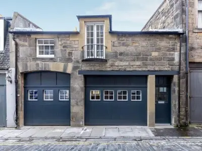 a pair of garage doors on a brick building at Dragon Suites - Yukina Suite - 2 bed city centre house with garden in Edinburgh