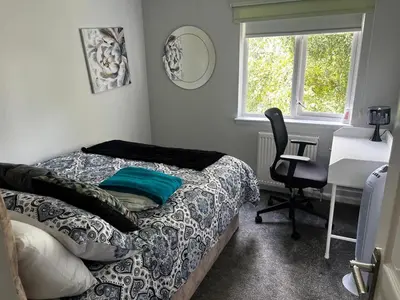 a bedroom with a bed and a desk and a chair at 5 minutes to Glasgow airport in Paisley