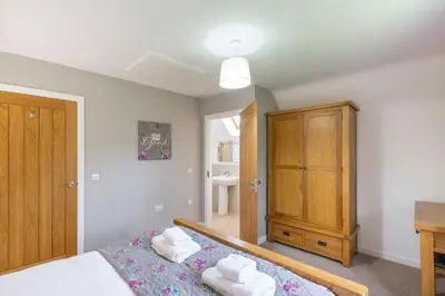 a bedroom with a bed and a wooden cabinet at Lord Galloway 31 with Hot Tub in Newton Stewart