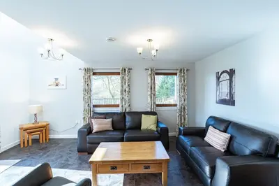 a living room with a couch and a table at Lord Galloway 31 with Hot Tub in Newton Stewart