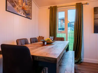 a dining room table with chairs and a large window at Chalet Loch Leven Lodge 25 East by Interhome in Kinross