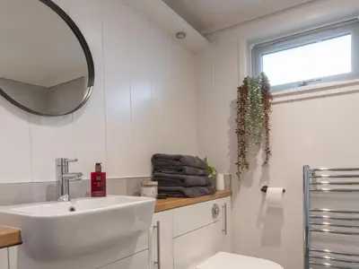 a white bathroom with a sink and a mirror at Chalet Loch Leven Lodge 25 East by Interhome in Kinross