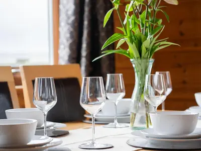 a table with wine glasses and a vase with flowers at Chalet Loch Leven Lodge 10 by Interhome in Kinross