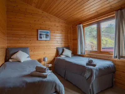 two beds in a log cabin with a window at Chalet Loch Leven Lodge 10 by Interhome in Kinross