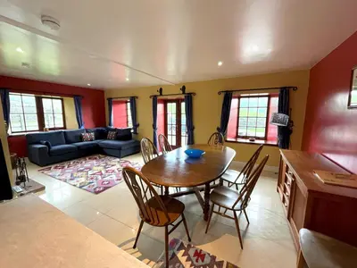a living room with a table and chairs and a couch at Beautiful Rural 3BR Cottage with Stunning Views - Pass the Keys in Auldgirth