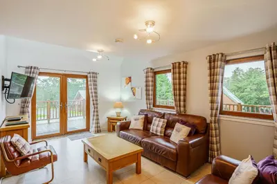 a living room with a couch and a table at Lord Galloway 35 with Hot Tub in Newton Stewart