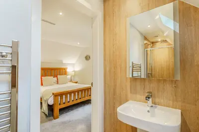 a bathroom with a sink and a bed and a mirror at Lord Galloway 36 with Hot Tub in Newton Stewart