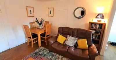 a living room with a leather couch and a table at Greenbrae East in Crieff