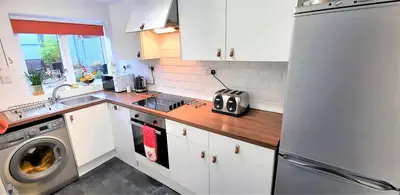 a kitchen with white cabinets and a stainless steel refrigerator at Greenbrae East in Crieff