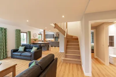 a living room with a couch and a staircase at Lord Galloway 39 with Hot Tub in Newton Stewart