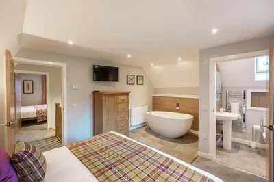 a bathroom with a tub and a sink and a bath tub at Lord Galloway 39 with Hot Tub in Newton Stewart