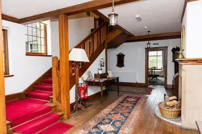 a living room with a staircase and a red rug at Newholme House in Stirling