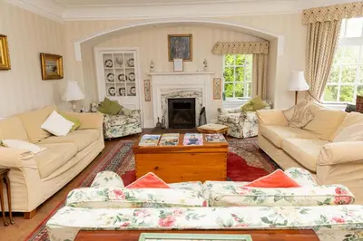 a living room with couches and a fireplace at Newholme House in Stirling