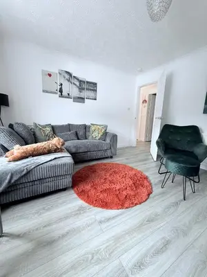 a living room with a couch and a red rug at Ochil View Holiday Let in Tullibody