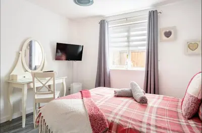 a bedroom with a bed and a desk and a mirror at Ochil View Holiday Let in Tullibody