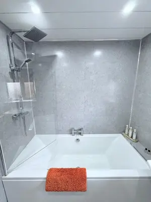 a white bath tub with a red towel on it at Ochil View Holiday Let in Tullibody