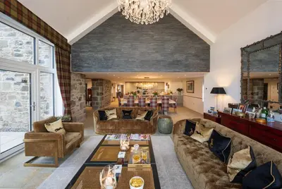 a living room with couches and a dining room at Kipney Farmhouse with hot tub in Perth