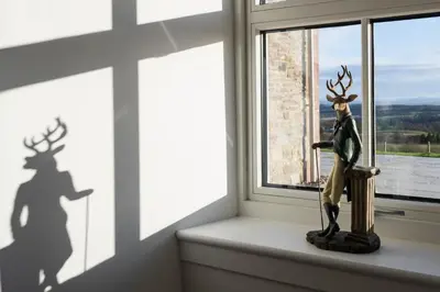 a statue of a reindeer sitting on a window sill at Kipney Farmhouse with hot tub in Perth