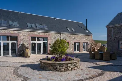 a brick building with a courtyard with a plant in the middle at Oystercatcher - Converted luxury steading in Perth