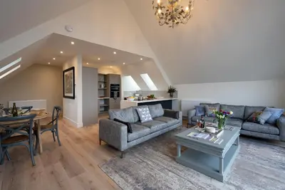 a living room with two couches and a table at Capercaillie Cottage - Luxury converted steading in Perth