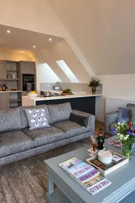 a living room with a couch and a table at Capercaillie Cottage - Luxury converted steading in Perth