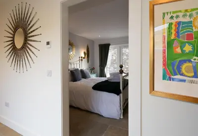 a bedroom with a bed and a mirror at Capercaillie Cottage - Luxury converted steading in Perth