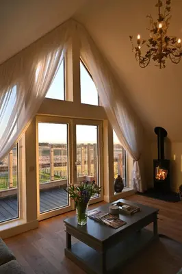 a living room with a large window and a table at Capercaillie Cottage - Luxury converted steading in Perth