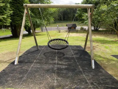 a swing seat in a park with a park at Birch Lodge 12 with Hot Tub in Newton Stewart