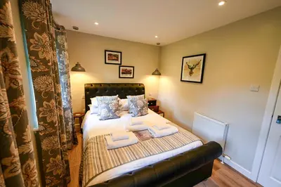 a bedroom with a bed with two towels on it at Bluebell Lodge 3 with Hot Tub in Newton Stewart