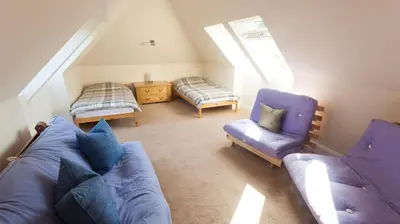 a living room with a couch and two chairs at The Byre in Strathyre