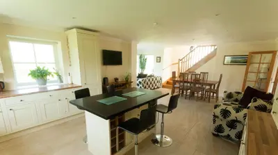 a kitchen and living room with a table and chairs at The Byre in Strathyre