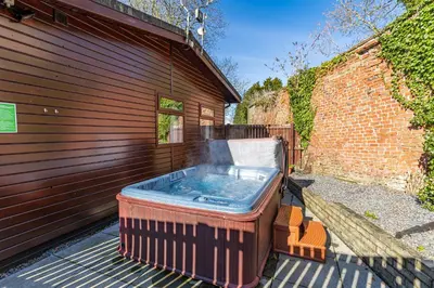 a hot tub sitting next to a building at Bluebell Lodge 7 with Hot Tub in Newton Stewart