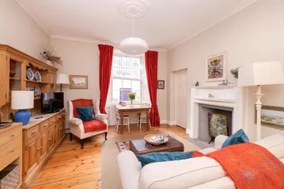 a living room with a couch and a fireplace at Charming Hideaway in Edinburgh City Centre in Edinburgh