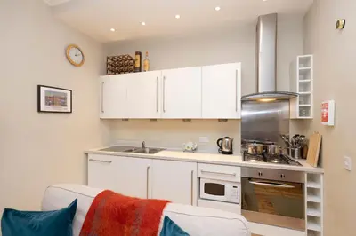 a kitchen with white cabinets and a stove top oven at Charming Hideaway in Edinburgh City Centre in Edinburgh