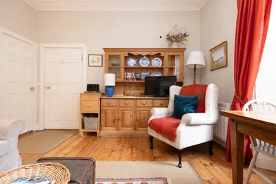 a living room with a chair and a television at Charming Hideaway in Edinburgh City Centre in Edinburgh