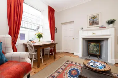 a living room with a table and a fireplace at Charming Hideaway in Edinburgh City Centre in Edinburgh