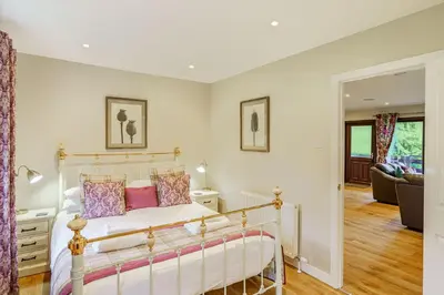 a bedroom with a bed and a living room at Bluebell Lodge 10 with Hot Tub in Newton Stewart