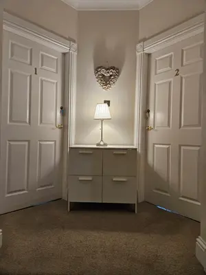 a room with two doors and a lamp on a dresser at Langhouse Castle Bed and Breakfast in Inverkip
